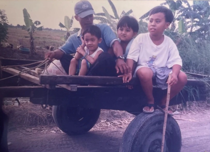 Quin Díaz as a child with his father and brothers on a wooden cart in the Philippines
